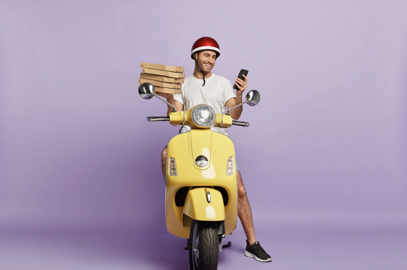 delivery driver holding pizza boxes in one hand and a mobile phone on the other hand